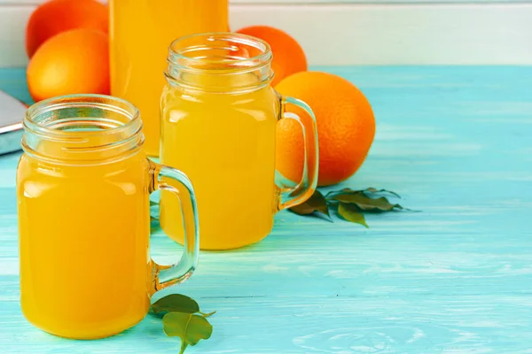 緑の木製テーブルの上にオレンジジュースとガラス — ストック写真