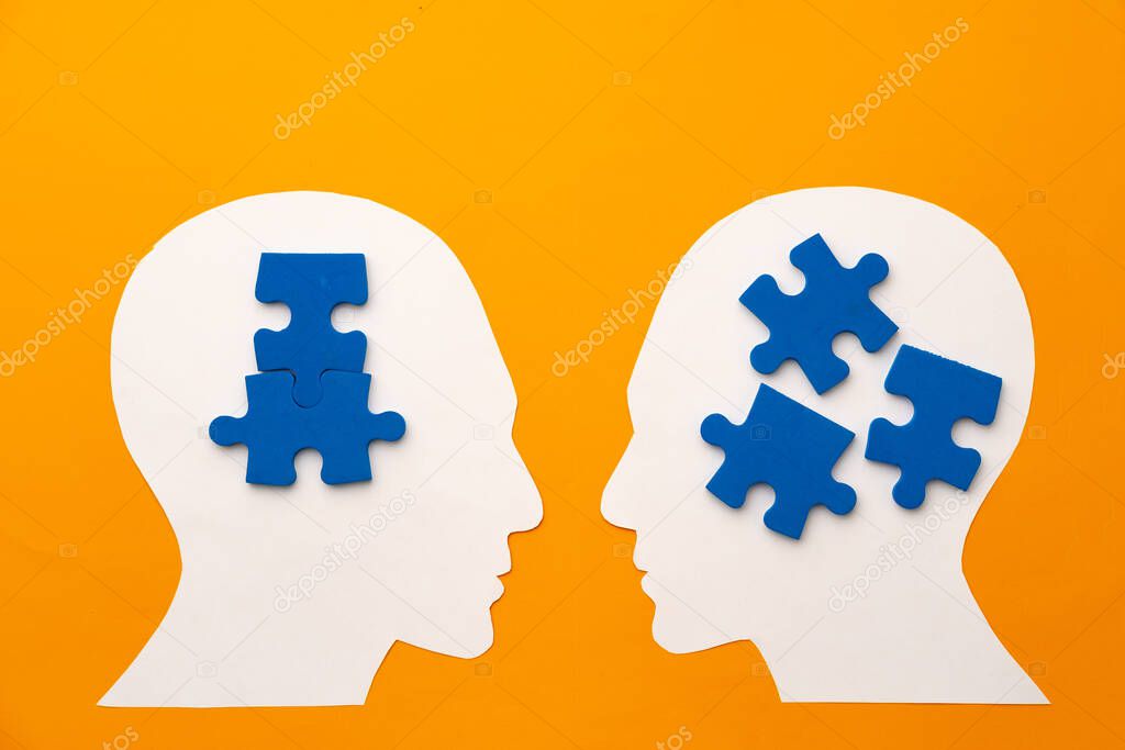 Papercut head silhouette with puzzle pieces on yellow background