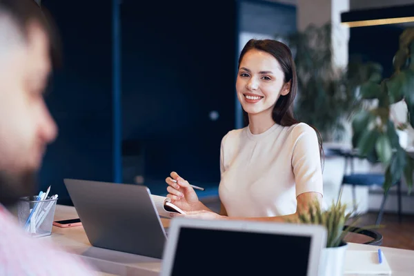 Ung attraktiv affärskvinna gör anteckningar i anteckningsblock på sin arbetsplats — Stockfoto