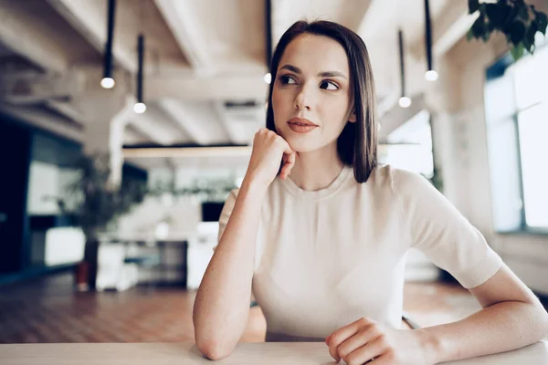 Jonge brunette vrouw zitten aan de tafel in office — Stockfoto