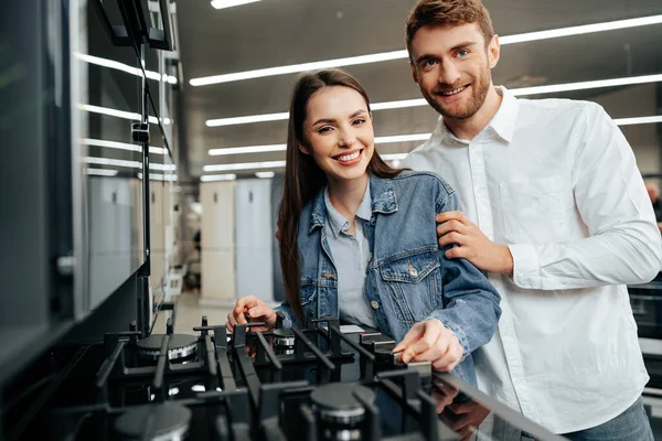 Unga par väljer ny gasspis i hushållsapparater butik — Stockfoto