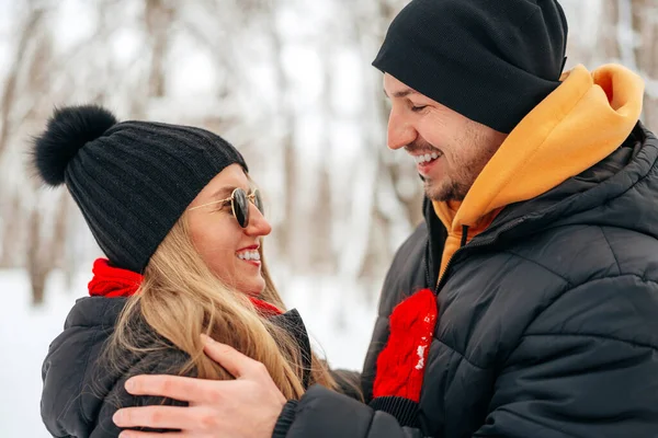 Happy couple hugging and smiling outdoors in snowy park — Stock Photo, Image