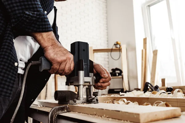 Carpenter cutting wood with electric jigsaw close up — Stock Photo, Image