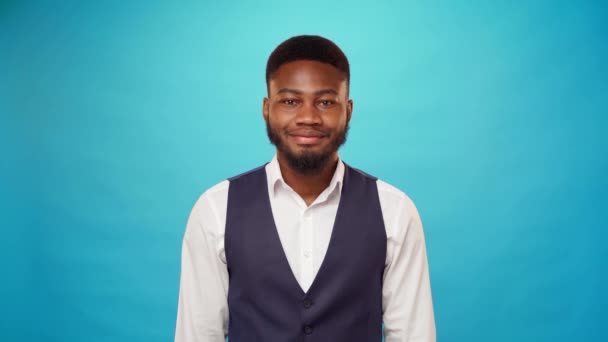 Hombre de negocios afroamericano sonriendo sobre fondo azul — Vídeos de Stock