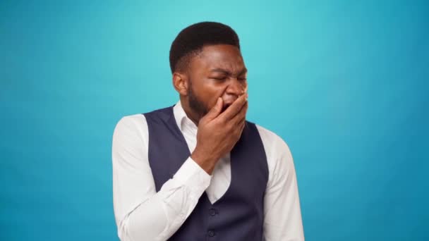 Cansado sonolento homem africano bocejando e adormecendo, fundo azul — Vídeo de Stock