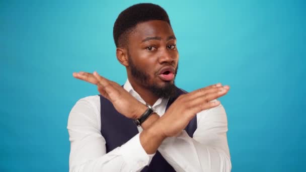 Young african american guy rejects something with crossed hands, says no, blue background — Stock Video