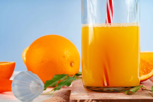 Botella de zumo de naranja y naranjas frescas en la mesa — Foto de Stock