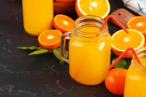 Склянка апельсинового соку і нарізані апельсини на столі — стокове фото