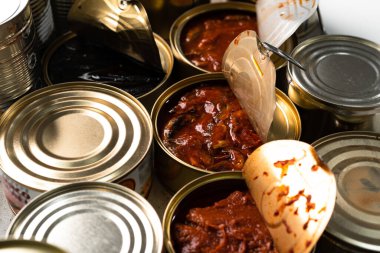 Bir sürü konserve balık ve ahşap masa.