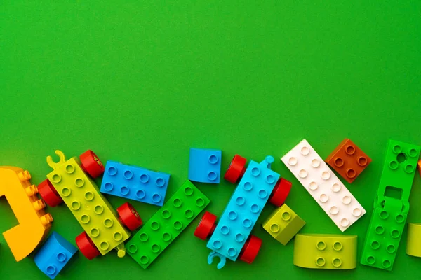 Dettagli di bambini costruttore di plastica su sfondo verde — Foto Stock