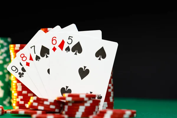 Červená hrací žetony a karty na pokerovém stole — Stock fotografie