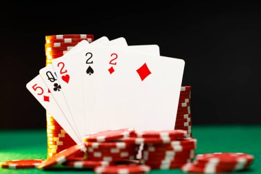 Poker masasında kırmızı oyun fişleri ve kartları