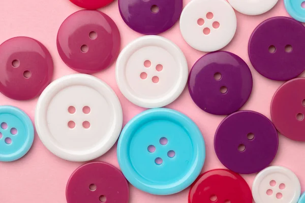 Пластикові кнопки на рожевому пастельному фоні зверху — стокове фото