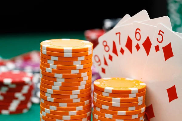 Playing cards and chips on green casino table background