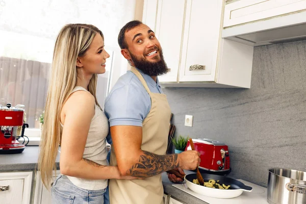 Jovem e mulher cozinhar comida na cozinha juntos, casal feliz preparando comida — Fotografia de Stock