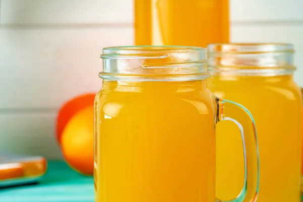 Glass with orange juice on green wooden table — Stock Photo, Image