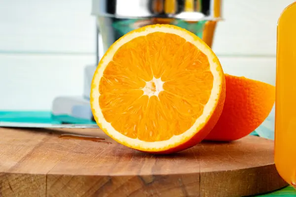Cut oranges on wooden board on table — Stock Photo, Image
