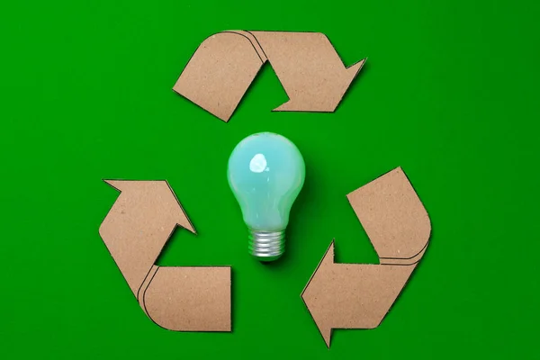Zöld hátterű izzólámpa és újrahasznosító tábla — Stock Fotó