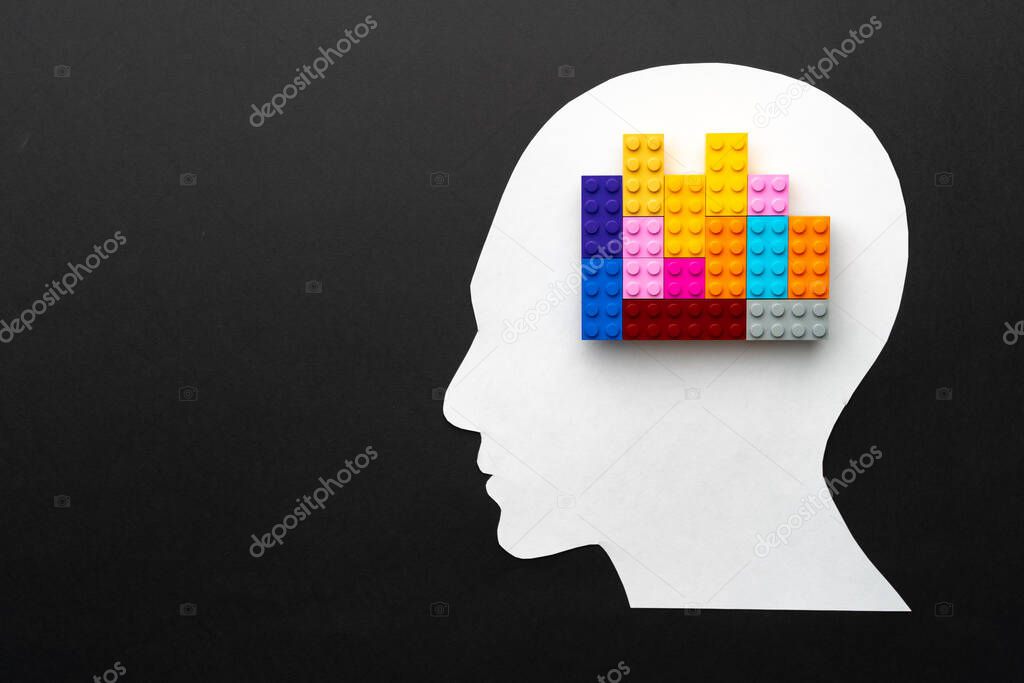 Papercut silhouette of human head with colorful constructor pieces