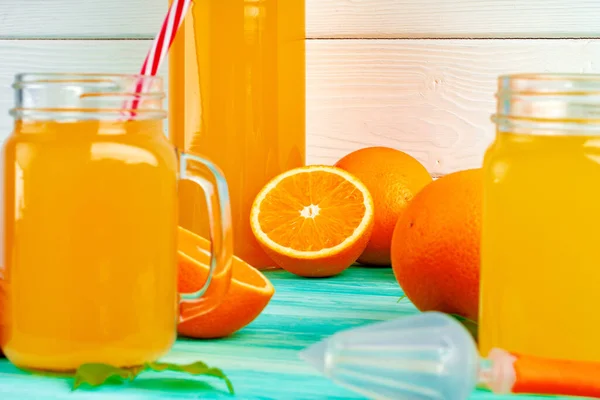 Vidro com suco de laranja na mesa de madeira verde — Fotografia de Stock