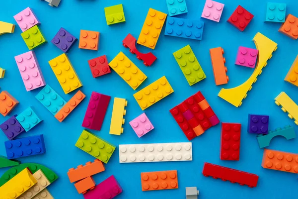 Flerfärgade bitar av leksak konstruktör på blå bakgrund — Stockfoto