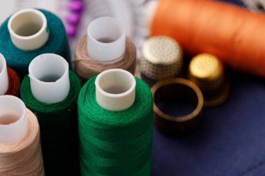 Kahverengi ahşap masada iplikler ve dikiş aksesuarları.