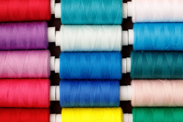 Close up of colored thread coils, thread spools background