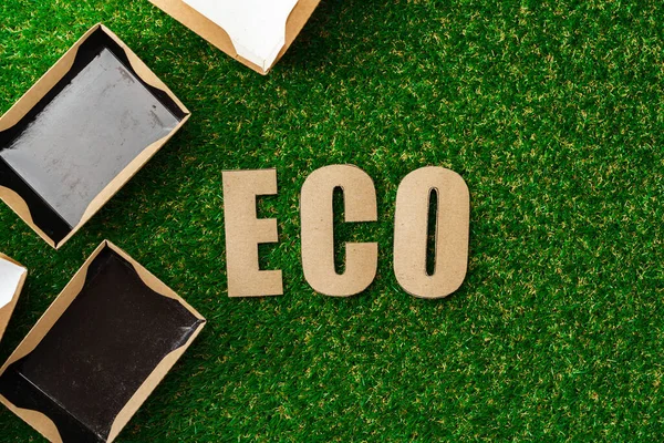 Wegwerp milieuvriendelijk kartonnen pakket op groene achtergrond — Stockfoto