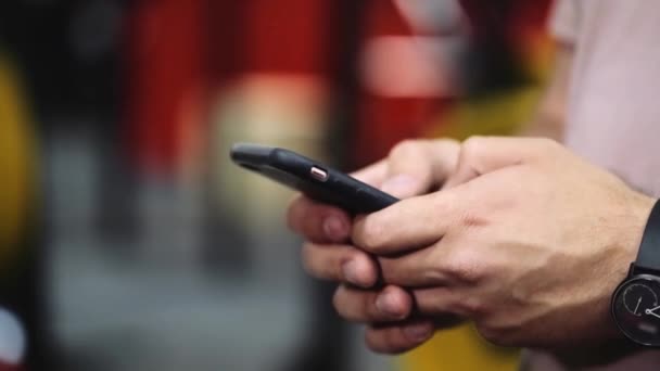 Tutup tangan mans yang memegang smartphone, menggunakan perangkat, latar belakang kabur — Stok Video