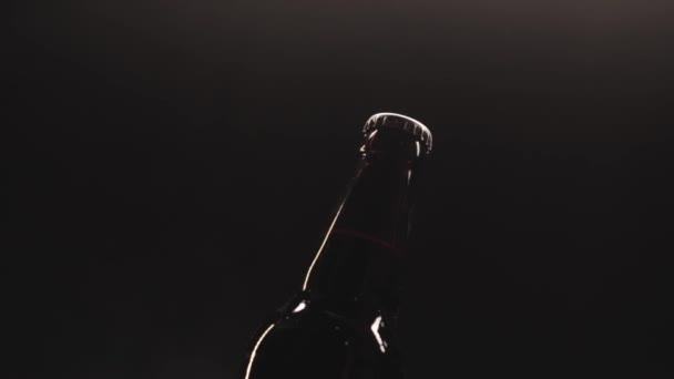 Öffnung der Bierflasche mit Flaschenöffner vor schwarzem Hintergrund — Stockvideo
