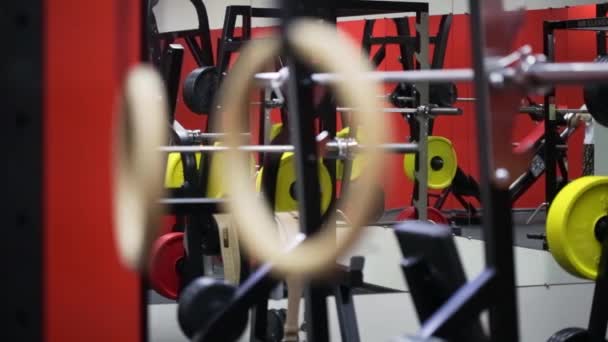 Anéis de ginástica balançando após o uso em um ginásio esportivo — Vídeo de Stock