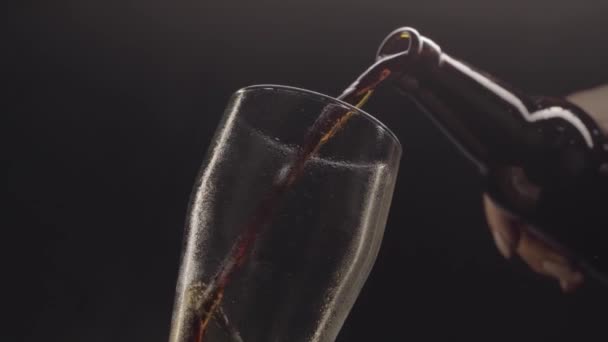 Birra versando in un bicchiere su sfondo nero — Video Stock