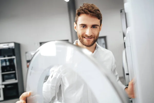 Hombre joven eligiendo una nueva lavadora en la tienda de electrodomésticos — Foto de Stock