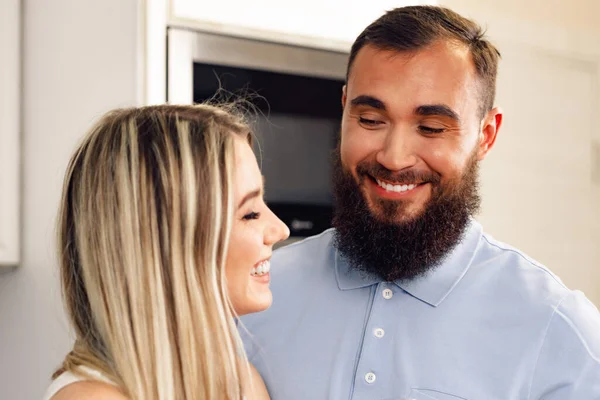 Close up de casal feliz sorrindo em pé na cozinha — Fotografia de Stock