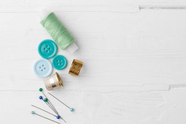 Beyaz ahşap masada renkli dikiş aksesuarları