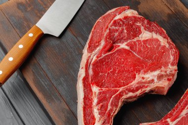 Kahverengi ahşap tahtada çiğ biftek.