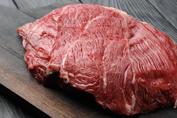 Peça de filé de carne crua na placa de madeira de perto — Fotografia de Stock