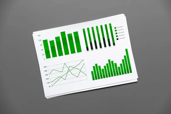 グレーテーブルのチャートと図付きの財務紙 — ストック写真