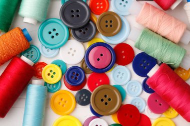 Beyaz ahşap masada renkli dikiş aksesuarları