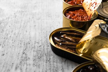 Bir sürü konserve balık ve ahşap masa.