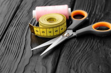 Siyah ahşap yüzeyde renkli dikiş aletleri