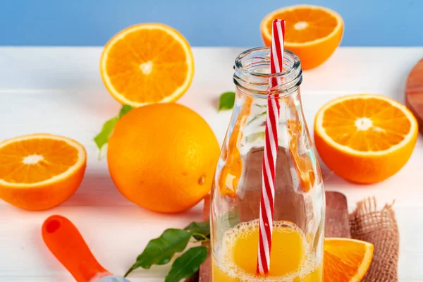 Bottle of orange juice and fresh oranges on table — Stock Photo, Image