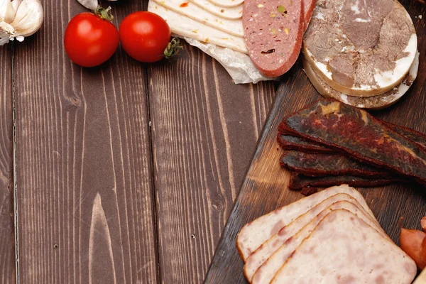Asortyment mięsa i kiełbasy na powierzchni drewnianej — Zdjęcie stockowe