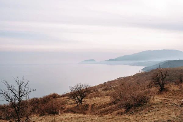 Autumn coast with blue sea and rocky land — Stock Photo, Image