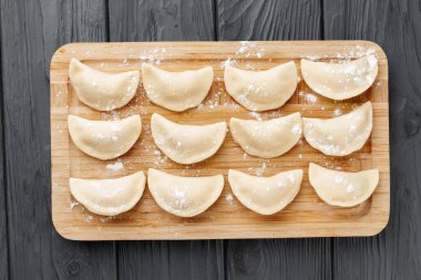 Çiğ çiğ hamur köfteleri masadaki tahtanın üzerinde.