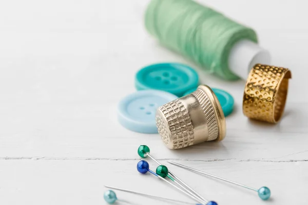 Kleurrijke naaiaccessoires op witte houten tafel — Stockfoto