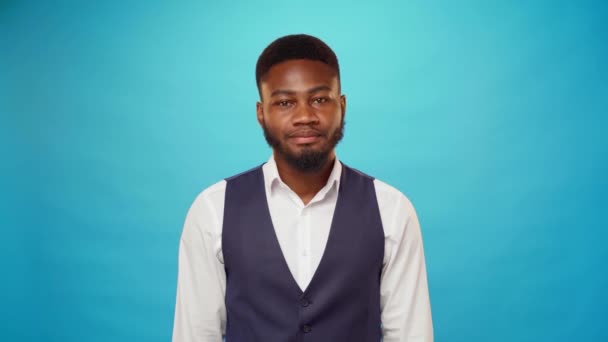 Hombre de negocios afroamericano sonriendo sobre fondo azul — Vídeos de Stock