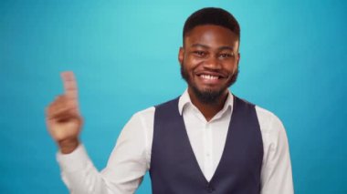 Afro-Amerikalı adam reklam için fotokopi alanını işaret ediyor, mavi arkaplan