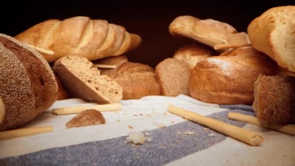 Ассортимент свежего хлеба на скатерти, увеличение видео — стоковое видео