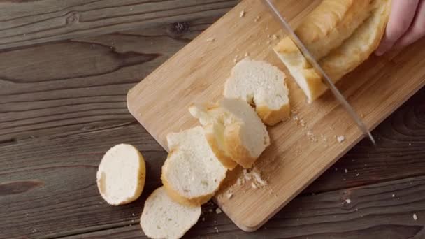 Руки жінки, що ріже хлібний хліб на дерев'яній обробній дошці — стокове відео
